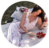 Model laying in at a picnic wearing a purple floral dress. Links to the dresses collection.