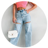Model wearing blue denim jeans with a cutout rhinestone detail. Links to the restocks collection.