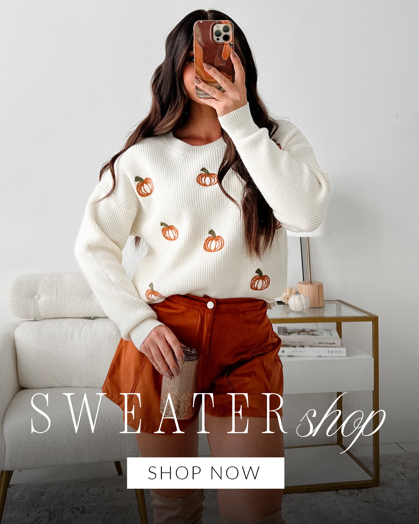 Photo of a model taking a selfie in a pumpkin embroidered sweater. Headline says "Sweater Shop" Call to Action says "Shop Now" and links to the sweaters collection.